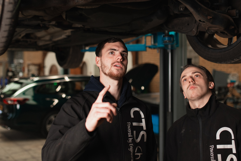 cts-performance personeel aan het werk onder een auto
